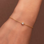 Bracelet délicat en argent 925 plaqué or avec pierre solitaire en oxyde de zirconium transparent, porté au poignet