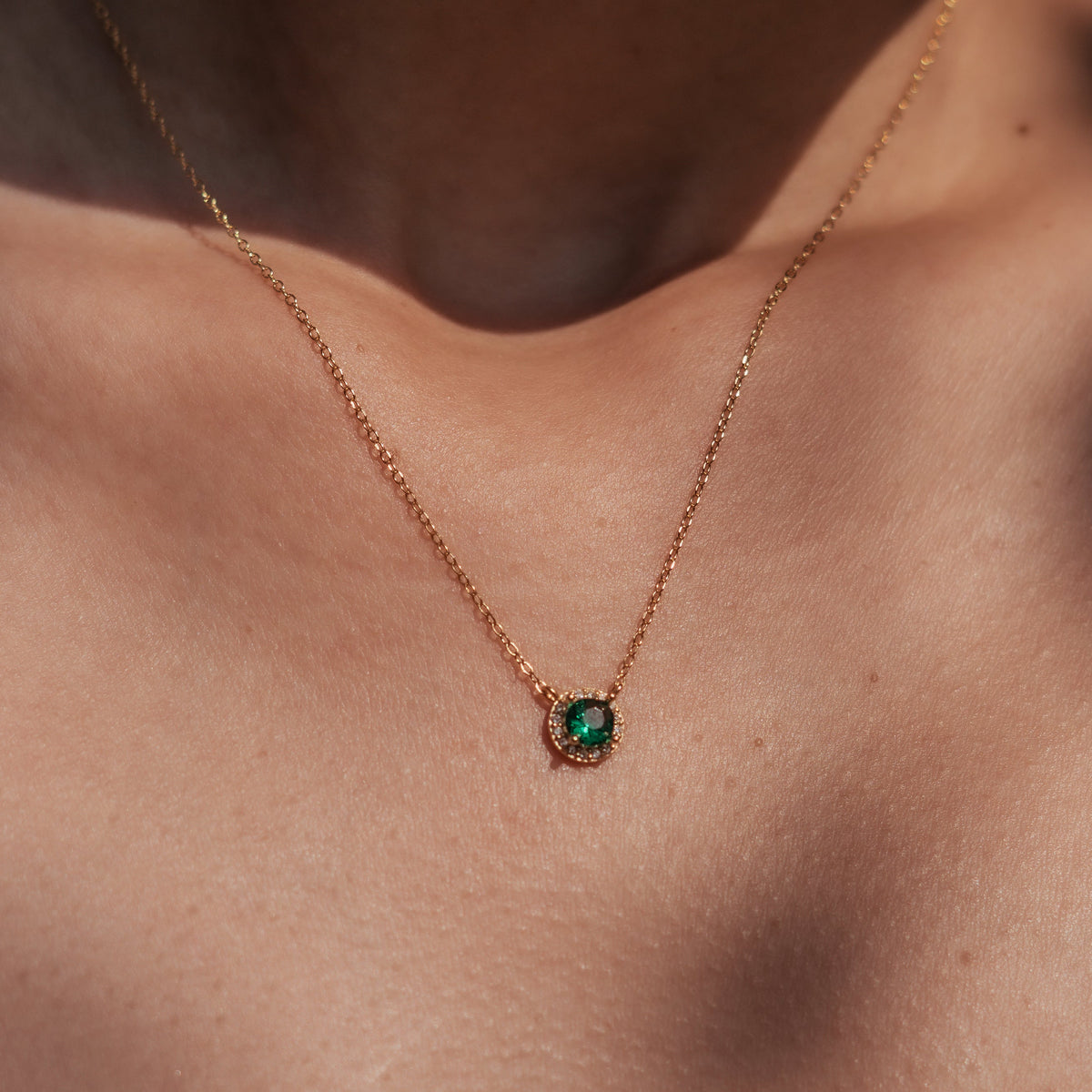 Collier en argent 925 plaqué or avec pendentif rond serti d’une pierre verte centrale entourée d’oxydes de zirconium transparents