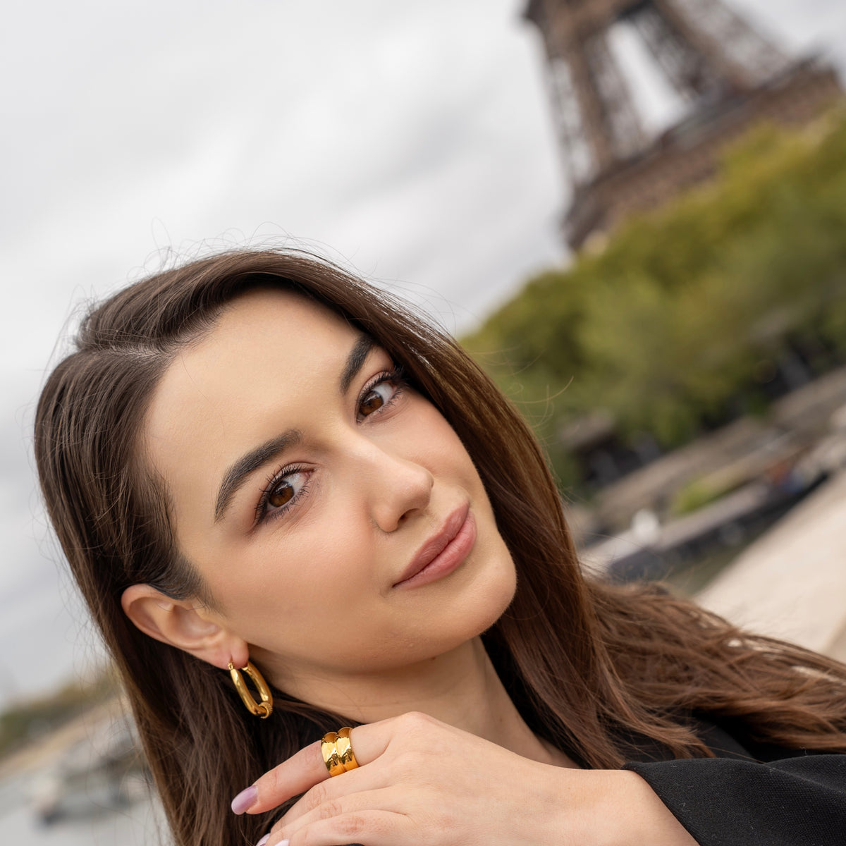 Boucles d’oreilles créoles ovales en acier inoxydable plaqué or avec détail torsadé, portées à l’oreille