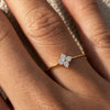 Gold-plated sterling silver flower ring with clear cubic zirconia stones worn on the finger.