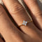 Gold-plated sterling silver flower ring with clear cubic zirconia stones worn on the finger.