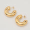 Gold-plated stainless steel chunky C-shaped hoop earrings with a smooth polished finish on a light background