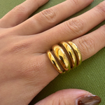 Gold-plated stainless steel chunky ring with four rounded parallel bands worn on the finger