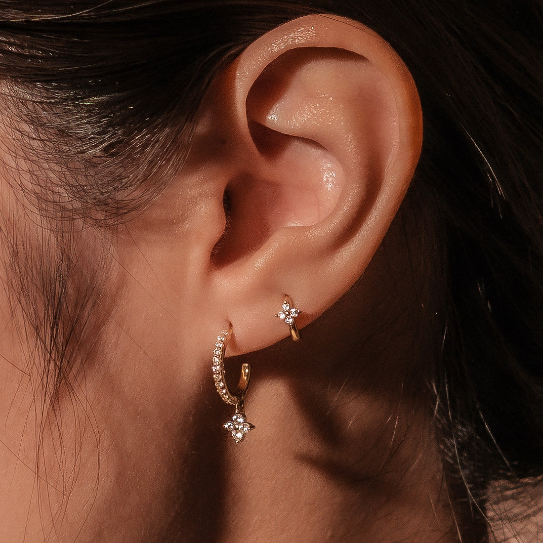 Gold-plated stainless steel huggie earrings with clear cubic zirconia and small flower details