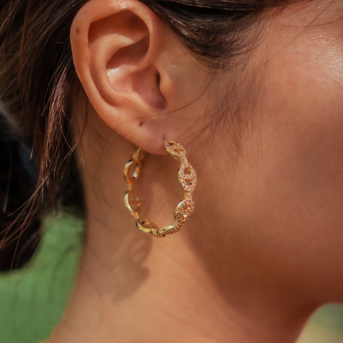 Gold-plated stainless steel hoop earrings with oval link details and clear cubic zirconia stones