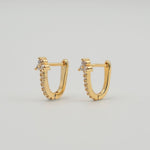 Gold-plated stainless steel rectangular huggie earrings with clear cubic zirconia stones on a light background