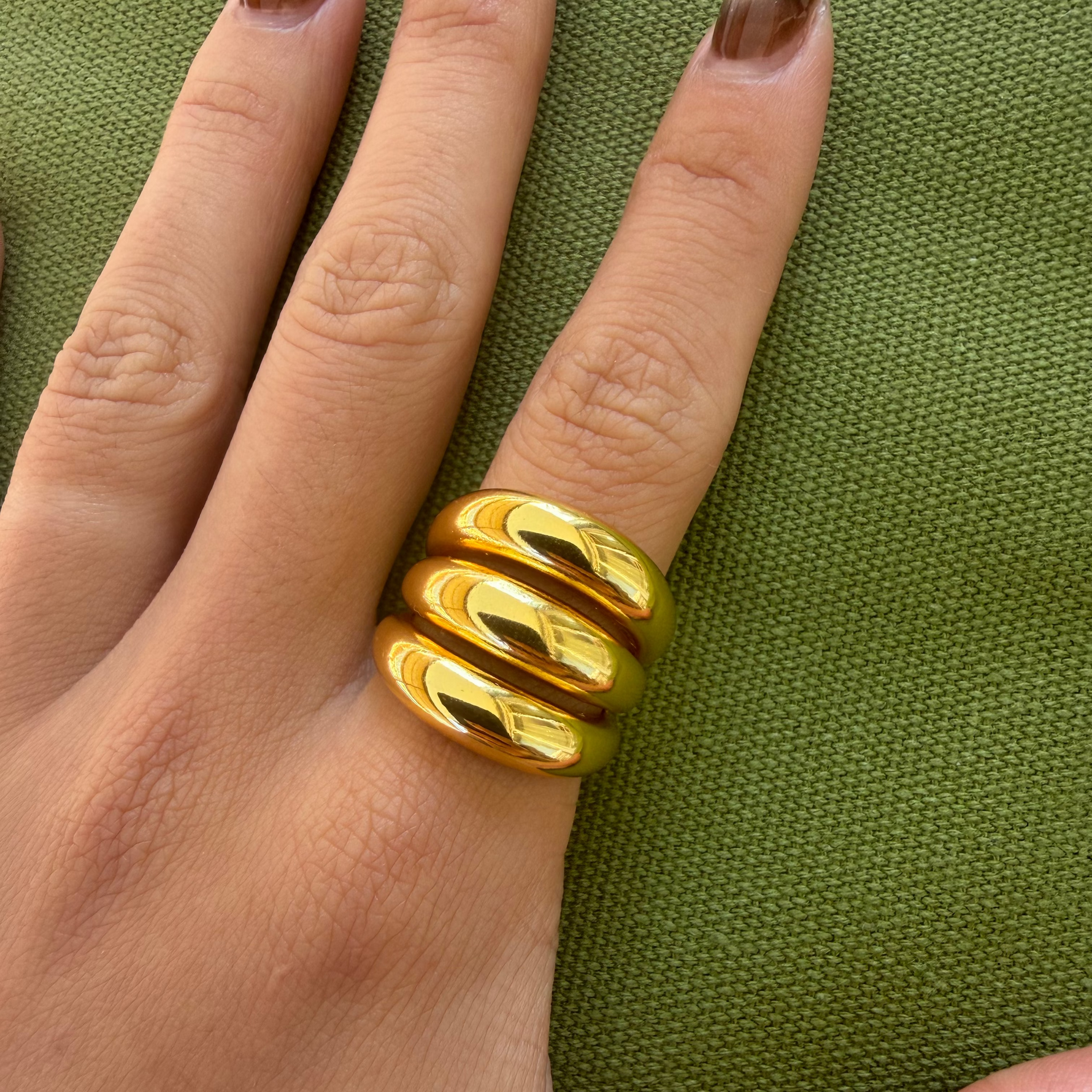 Gold-plated stainless steel chunky ring with three rounded stacked bands worn on the finger