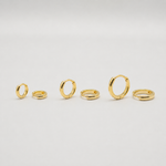 Gold-plated sterling silver classic huggie hoop earrings with a smooth polished finish on a light background