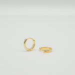 Gold-plated sterling silver classic huggie hoop earrings with a smooth polished finish on a light background
