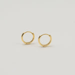 Gold-plated sterling silver classic huggie hoop earrings with a smooth polished finish on a light background