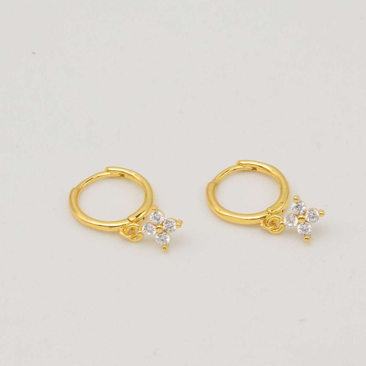Gold-plated sterling silver hoop earrings with clear cubic zirconia star-shaped drops 
