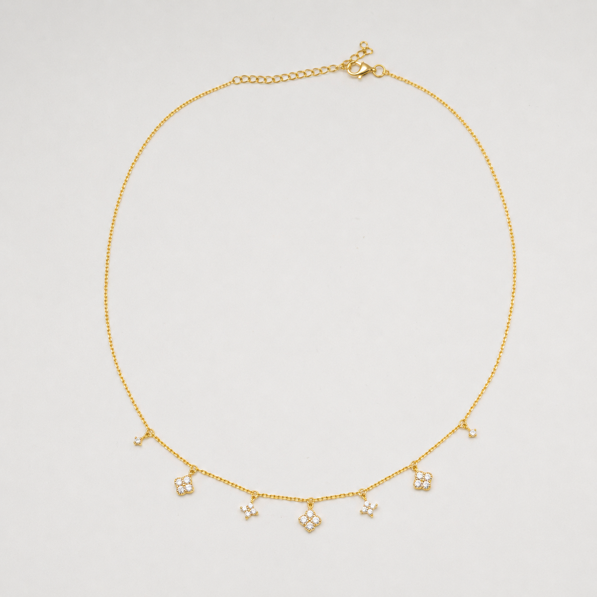 Gold-plated sterling silver necklace with five small clear cubic zirconia flower charms 