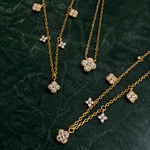 Gold-plated sterling silver necklace with five small clear cubic zirconia flower charms 