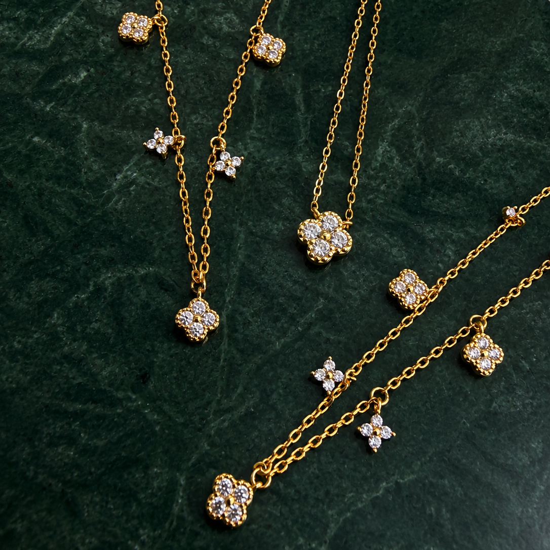 Gold-plated sterling silver necklace with five small clear cubic zirconia flower charms 