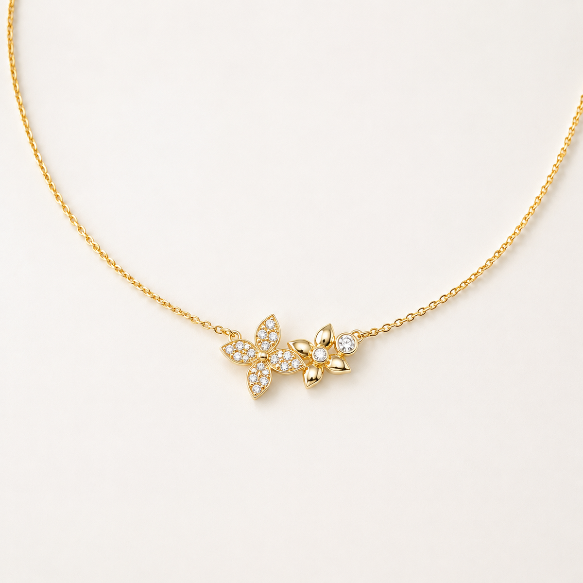 Gold-plated sterling silver necklace with floral and leaf motifs set with clear cubic zirconia stones