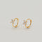 Gold-plated sterling silver huggie earrings with four-petal cubic zirconia flower details on a light background