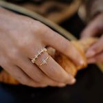 Gold-plated sterling silver flower ring stack with clear cubic zirconia stones worn on the finger.