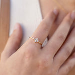 Gold-plated sterling silver flower ring with clear cubic zirconia stones worn on the finger.