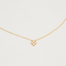 Gold-plated sterling silver necklace with a four-petal cubic zirconia pendant on a light background