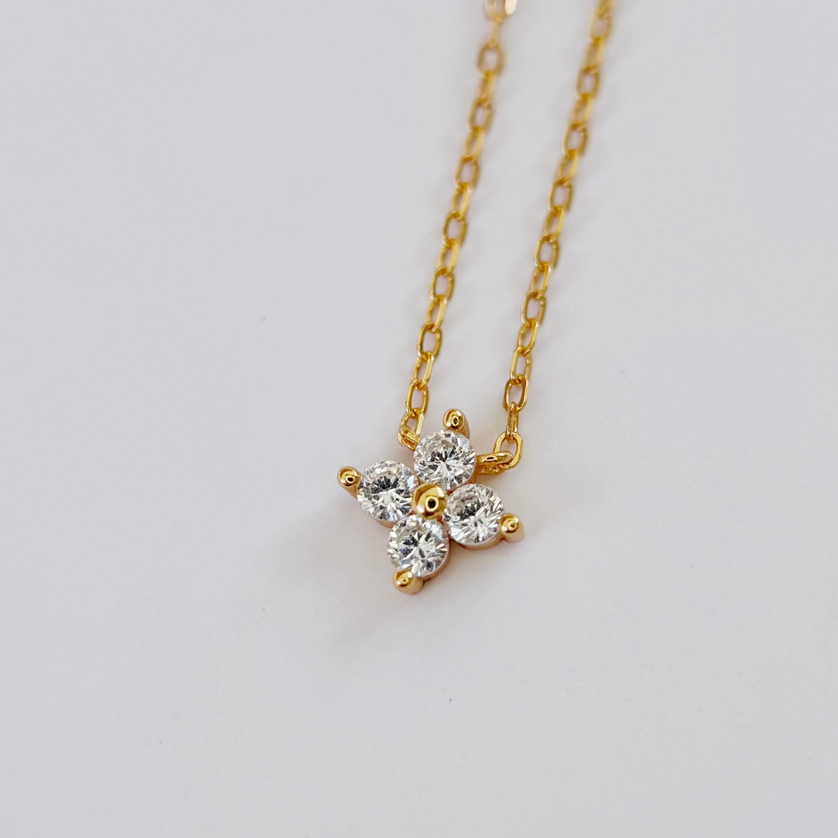 Gold-plated sterling silver necklace with a four-petal clear cubic zirconia pendant