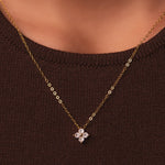 Gold-plated sterling silver necklace with a four-petal clear cubic zirconia pendant worn around the neck