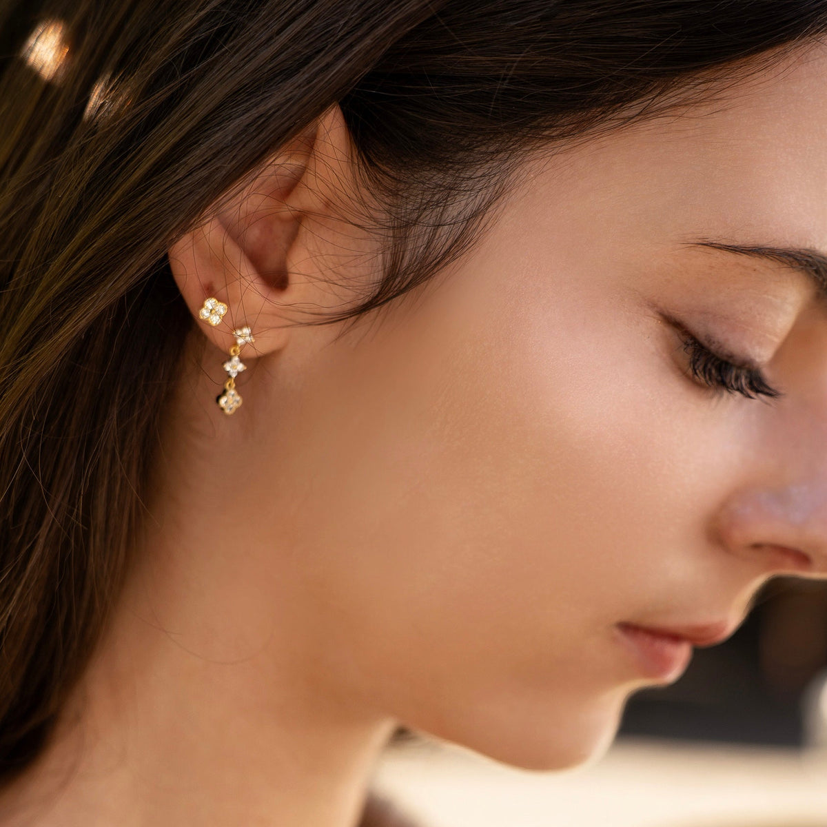 Gold-plated sterling silver round-back stud earring with a four-petal clear cubic zirconia design