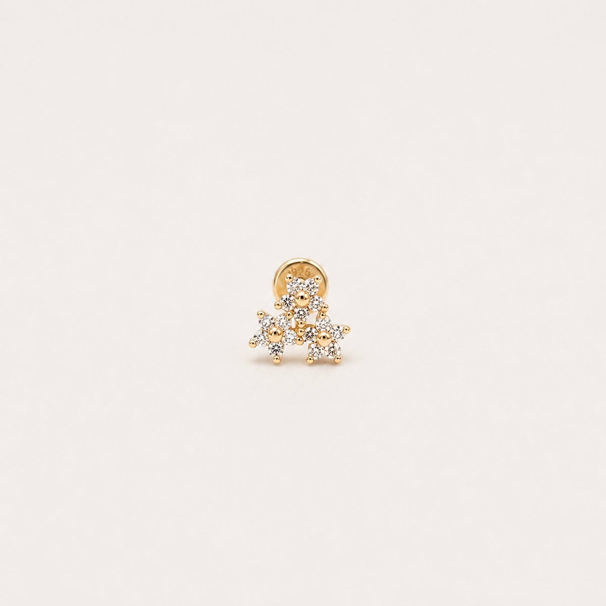 Gold-plated sterling silver huggie earring with a four-petal clear cubic zirconia flower design 