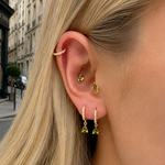 Gold-plated sterling silver stud earrings with green marquise-cut cubic zirconia stones worn on ear
