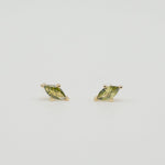Gold-plated sterling silver stud earrings with green marquise-cut cubic zirconia stones on a light background
