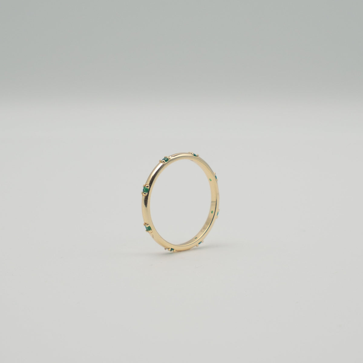 Gold-plated sterling silver delicate band ring with small green stones 