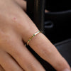 Gold-plated sterling silver delicate band ring with small green stones worn on the finger