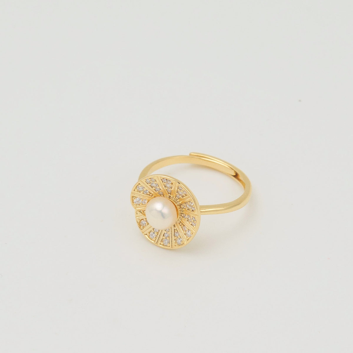 Gold-plated sterling silver ring with a central pearl surrounded by clear cubic zirconia details