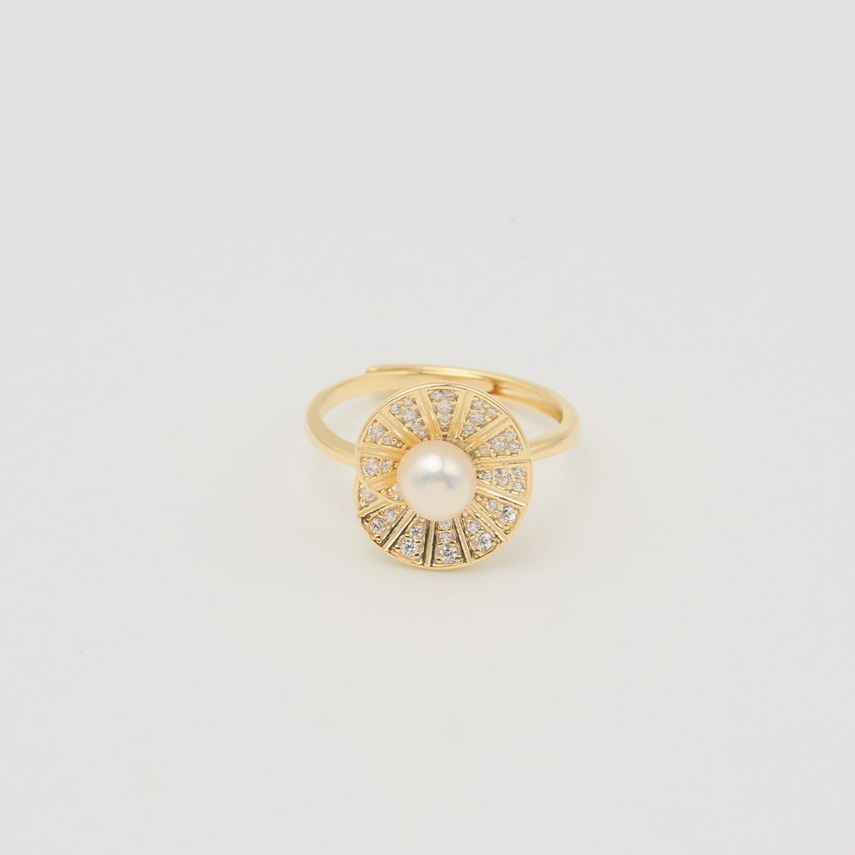 Gold-plated sterling silver ring with a central pearl surrounded by clear cubic zirconia details