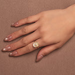 Gold-plated sterling silver ring with a central pearl surrounded by clear cubic zirconia details, worn on the finger