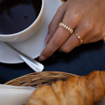 Gold-plated sterling silver ring with three small clover-shaped clear cubic zirconia details worn on the finger