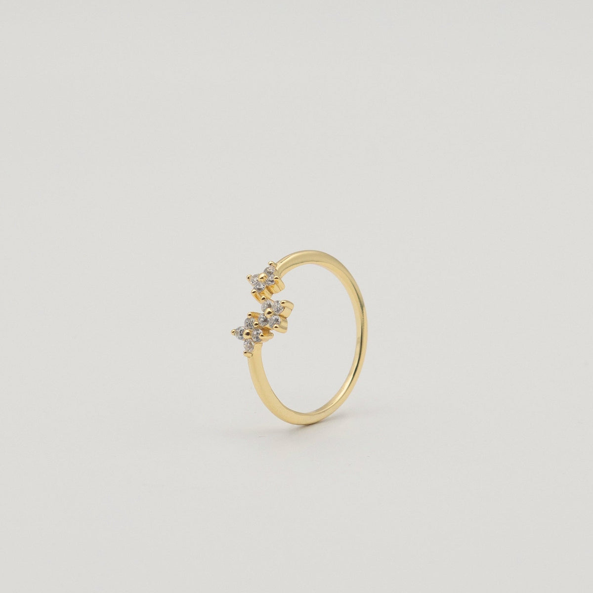 Gold-plated sterling silver ring with three flower motifs set with clear cubic zirconia stones