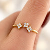 Gold-plated sterling silver ring with three flower motifs set with clear cubic zirconia stones, worn on the finger