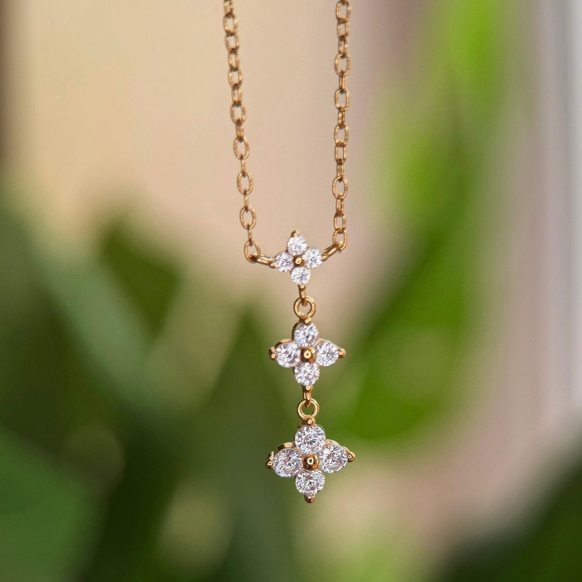 Gold-plated sterling silver drop necklace with three clear cubic zirconia flower motifs 