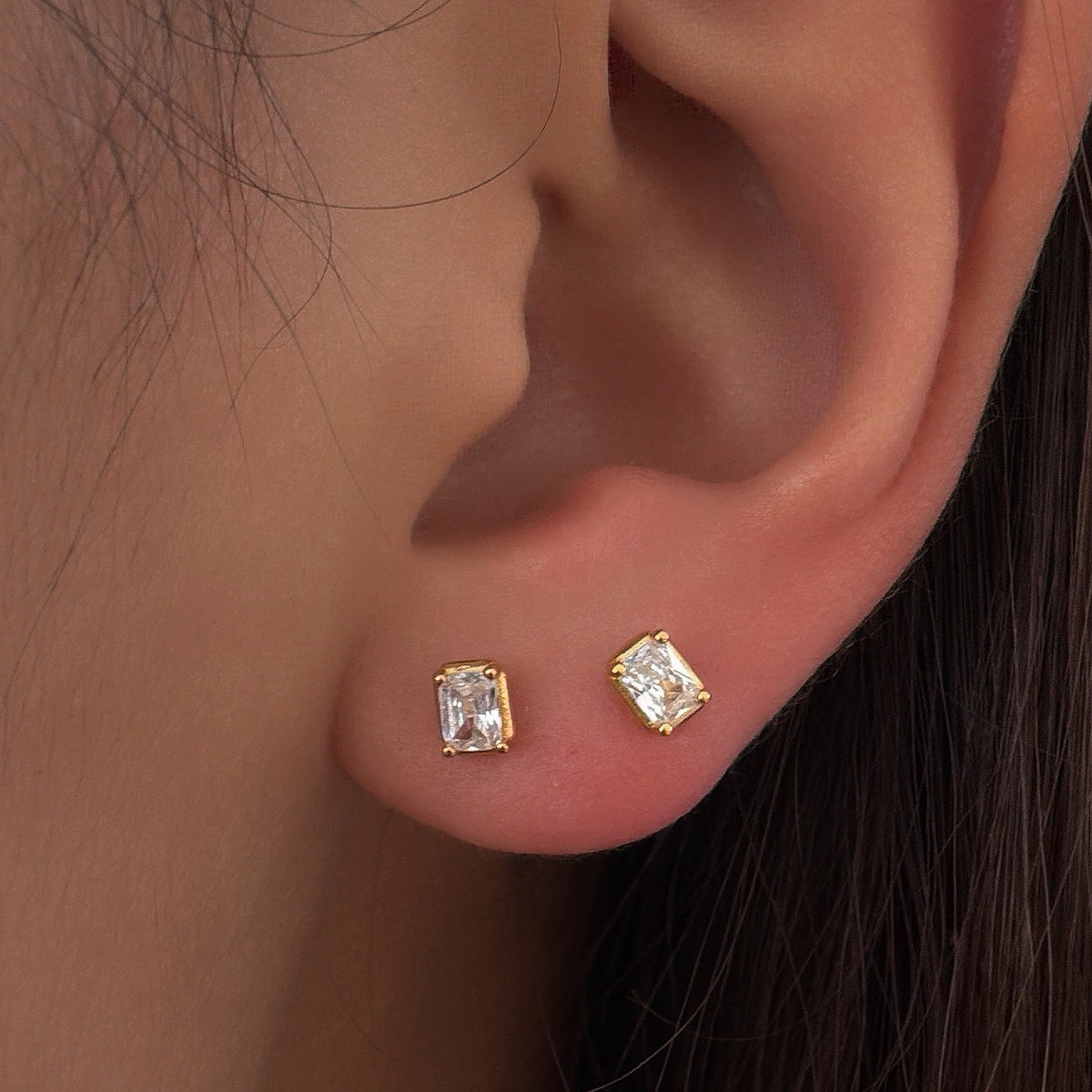 Puces d’oreilles en argent 925 plaqué or serties d’oxydes de zirconium transparents taille baguette, portées à l’oreille