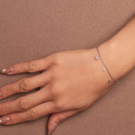 Rhodium-plated 925 sterling silver bracelet with cubic zirconia flower charms worn on wrist
