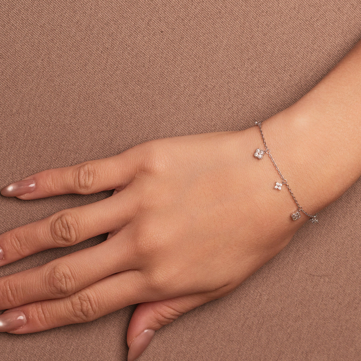 Rhodium-plated 925 sterling silver bracelet with cubic zirconia flower charms worn on wrist