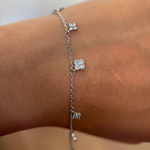 Rhodium-plated 925 sterling silver bracelet with cubic zirconia flower charms worn on the wrist