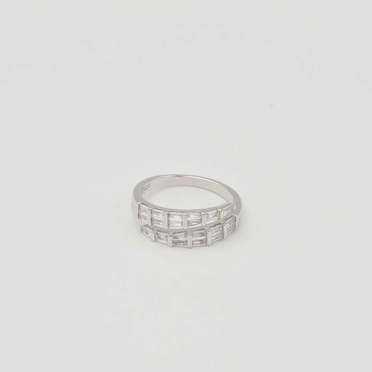 Rhodium-plated sterling silver band ring with two rows of baguette-cut clear cubic zirconia stones on a light background
