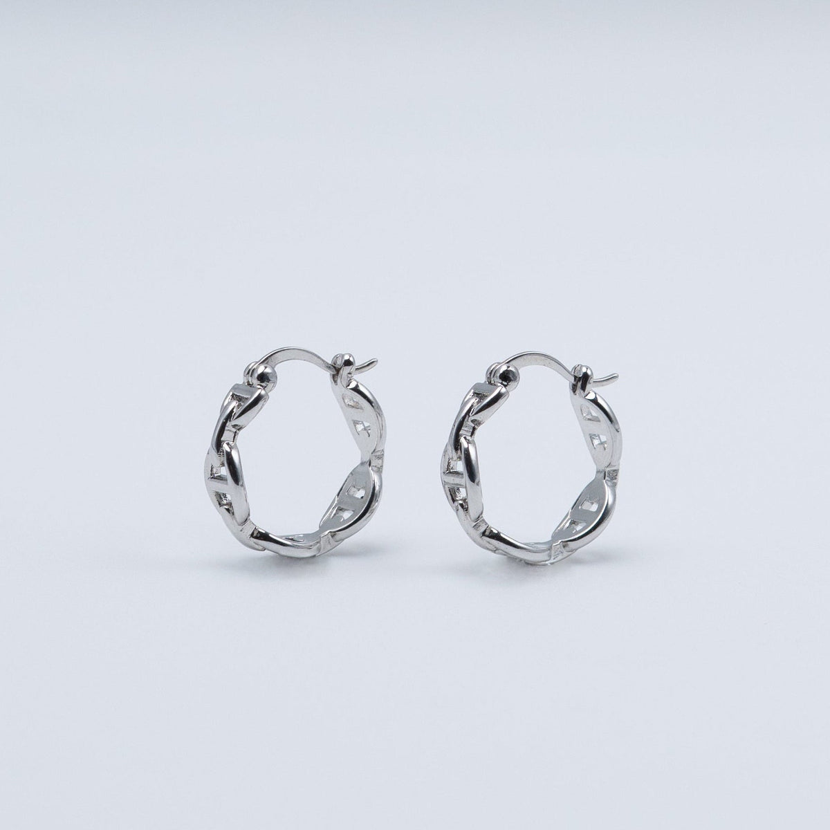 Rhodium-plated sterling silver hoop earrings with an interlocking chain-link design on a light background