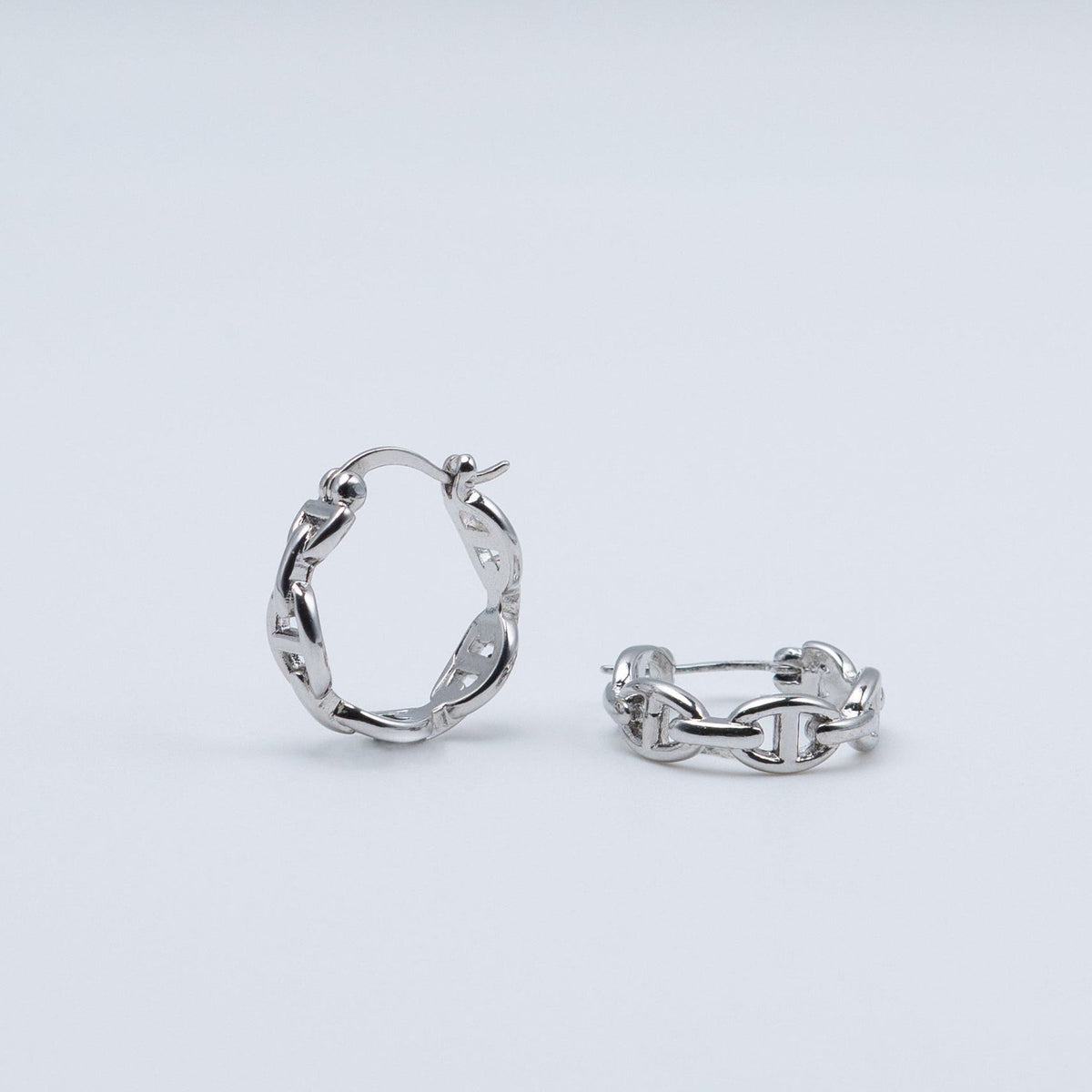 Rhodium-plated sterling silver hoop earrings with an interlocking chain-link design on a light background