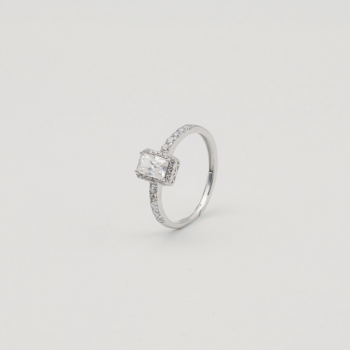 Rhodium-plated sterling silver solitaire ring with a cushion-cut moissanite center stone and pavé band 