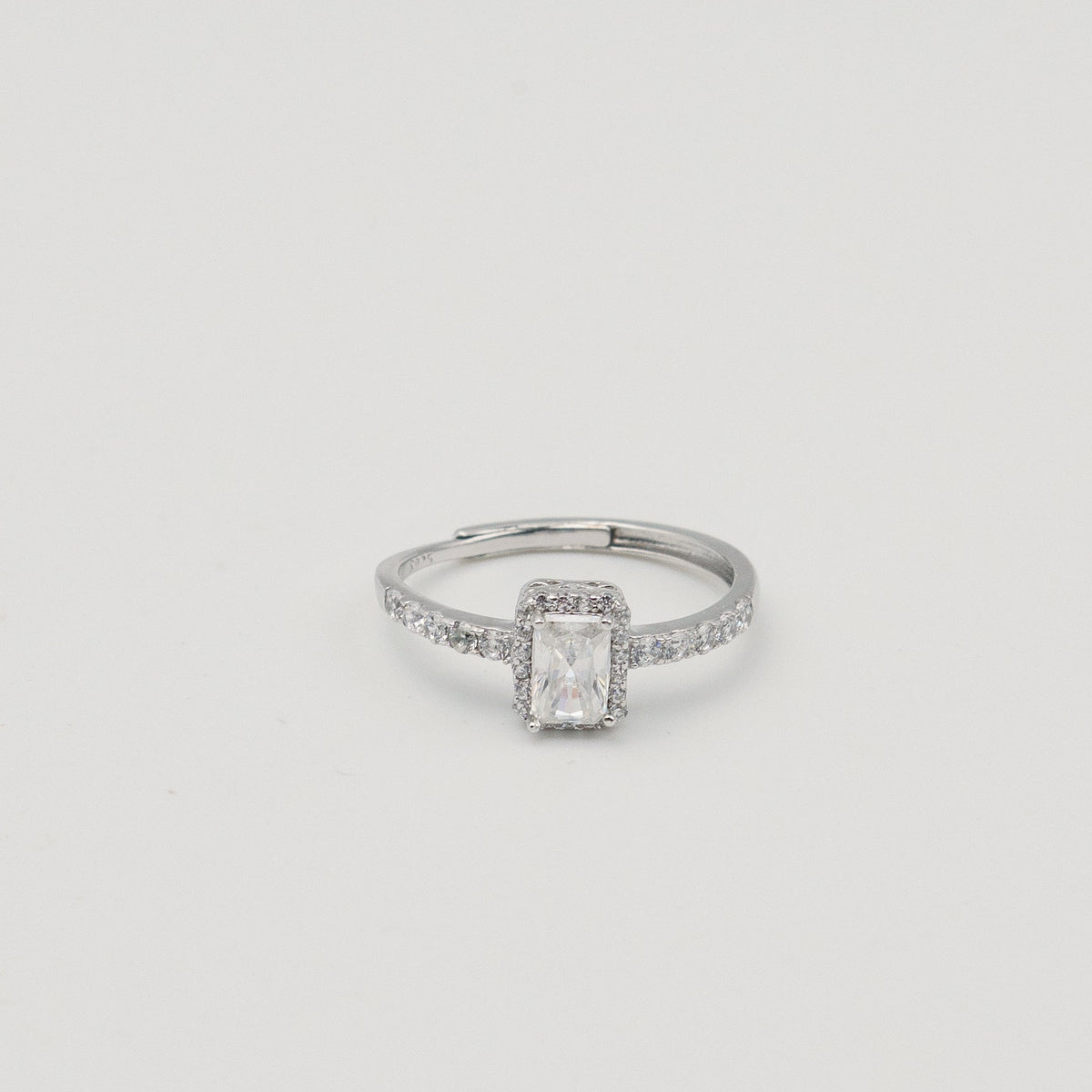 Rhodium-plated sterling silver solitaire ring with a cushion-cut moissanite center stone and pavé band 