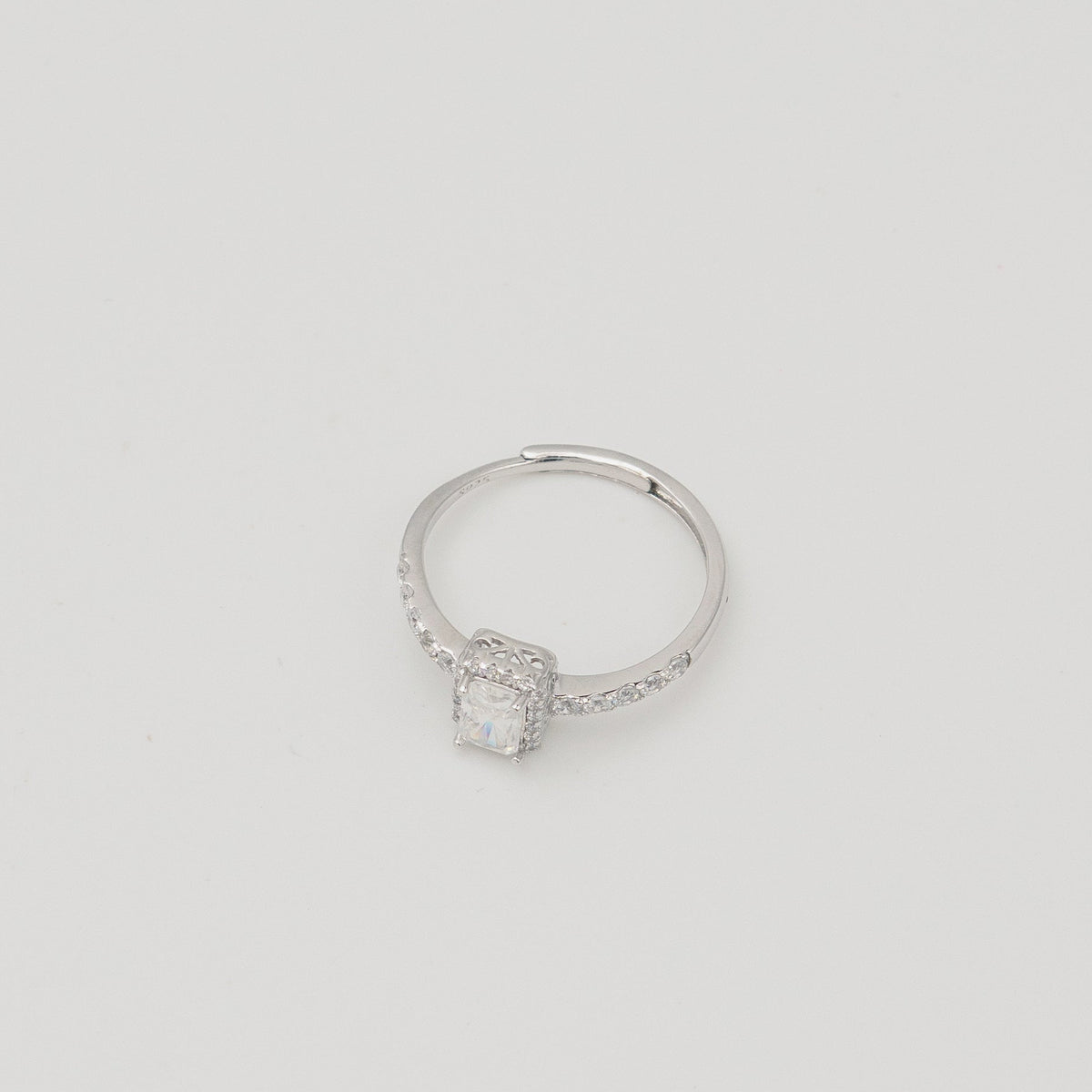 Rhodium-plated sterling silver solitaire ring with a cushion-cut moissanite center stone and pavé band