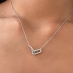 Rhodium-plated sterling silver necklace with interlocking double heart pendant and cubic zirconia stones worn on neck