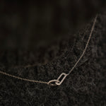 Rhodium-plated sterling silver necklace with interlocking double heart pendant and cubic zirconia stones